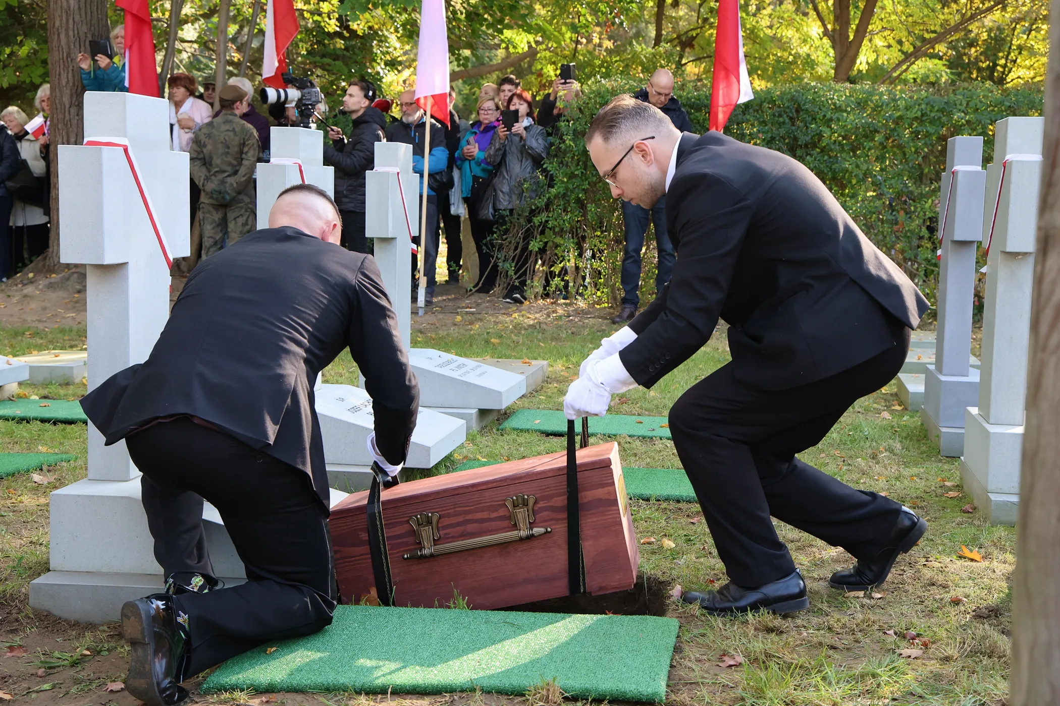Moment pochówku w czasie uroczystości pogrzebowej.
